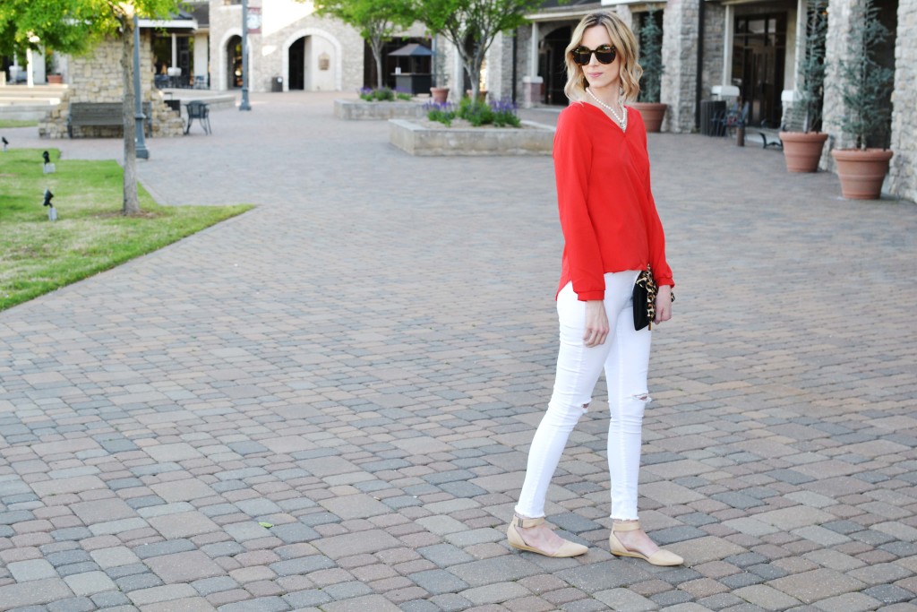 red top and white jeans with leopard clutch