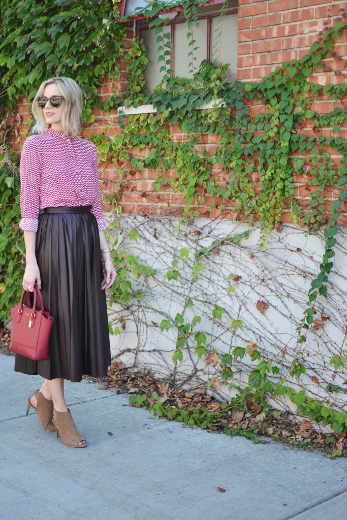burgundy pleated leather midi skirt, patterned red top, red bag, booties