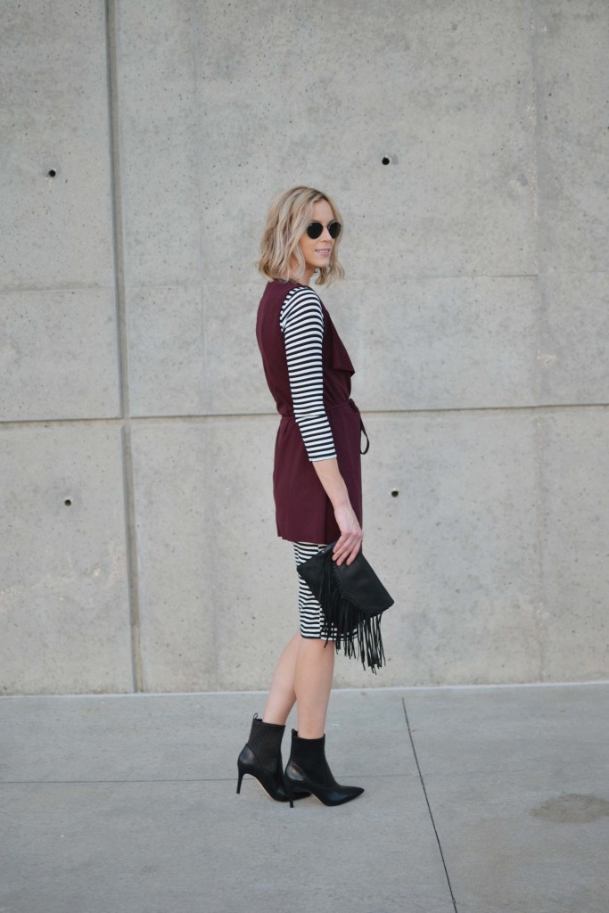 striped dress, burgundy vest, black boots, fringe bag, ray-bans