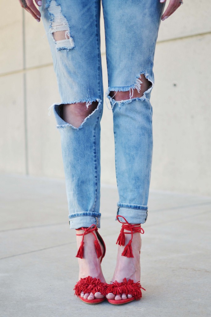 A sassy pair of red fringe shoes, fun embroidered top, and distressed jeans make for the perfect casual date night outfit.