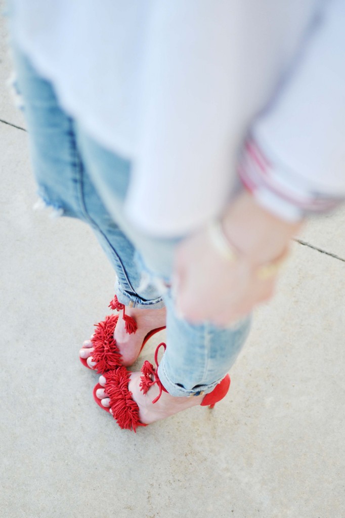 A sassy pair of red fringe shoes, fun embroidered top, and distressed jeans make for the perfect casual date night outfit.