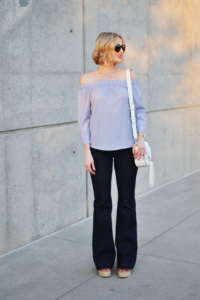 blue and white striped off the shoulder top, white tassel bag, flare jeans, wedges