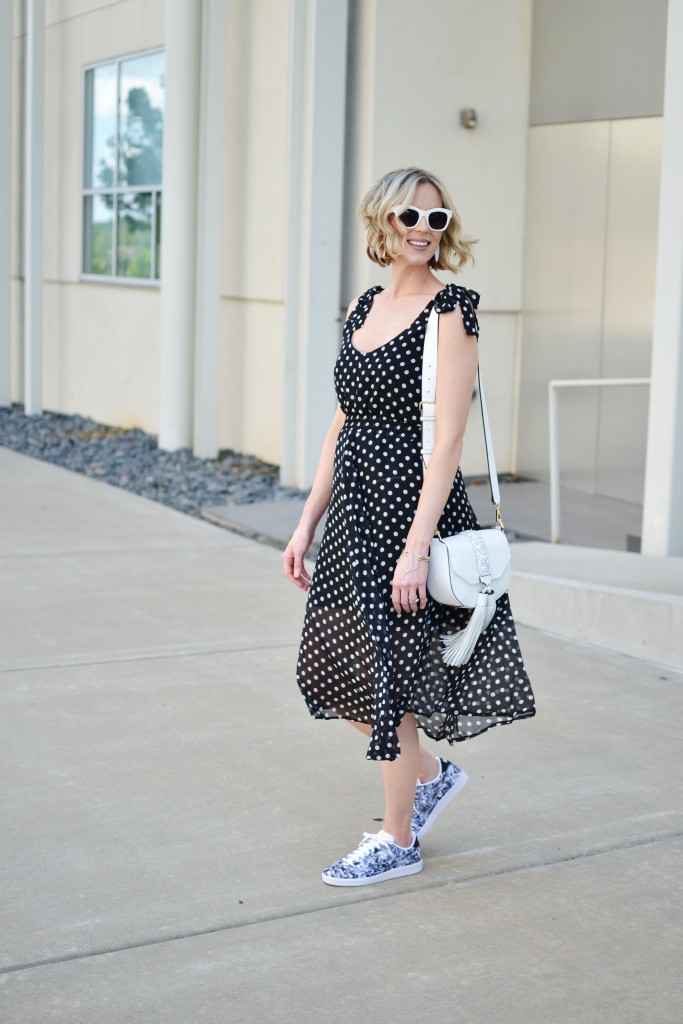 how to wear the sneaker trend, floral Nike sneakers, polka dot dress, white tassel bag, black and white, KicksUSA