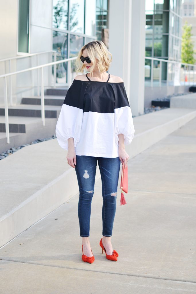 black and white cold color blocked cold shoulder top, distressed jean, red suede bow heels