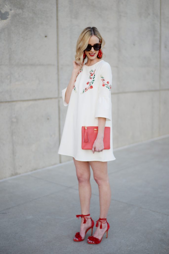 staying stylish on a budget, embroidered white dress, red tassel heels, red clutch
