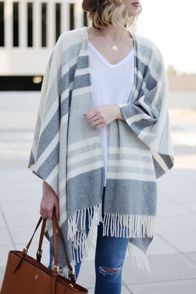 poncho styled over white t-shirt worn with jeans