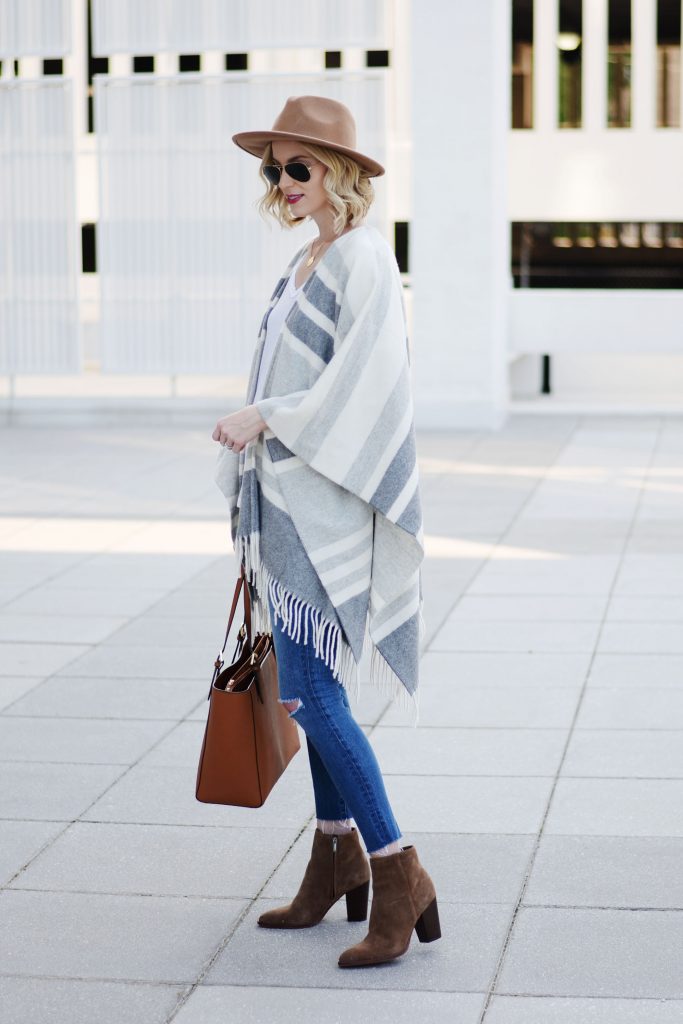 how to style a poncho with jeans, grey striped poncho with jeans and a hat