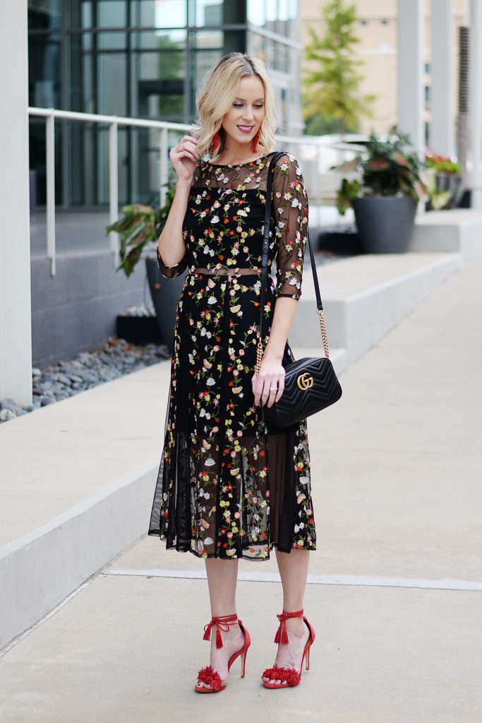 black floral midi dress with red heels, sheer panel cut outs, red statement earrings