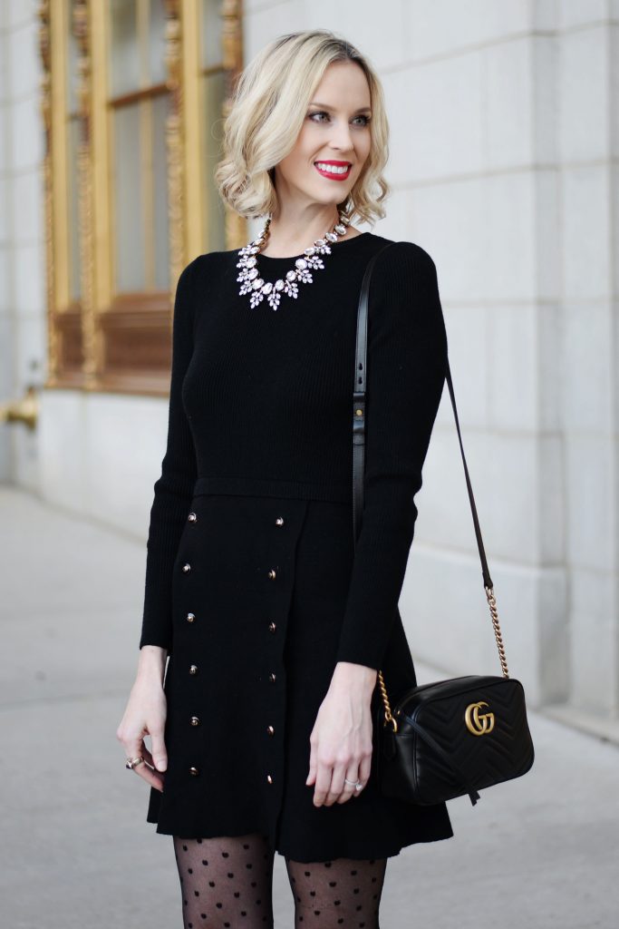 black sweater dress with gold buttons, statement crystal necklace 
