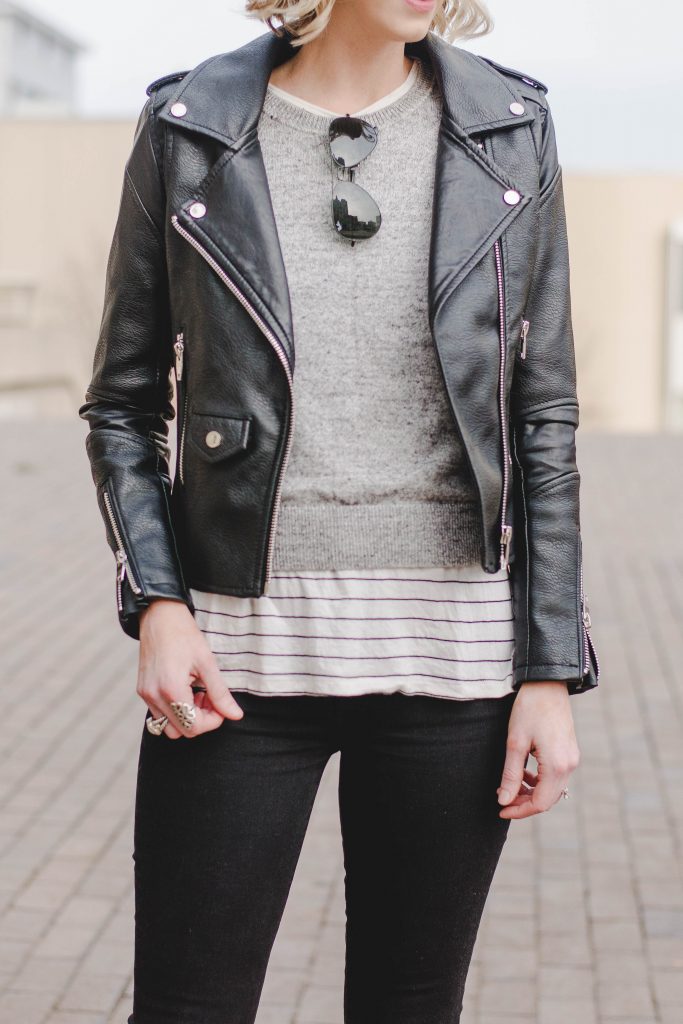 leather jacket with sweater, striped tee, and jeans, casual leather jacket outfit idea