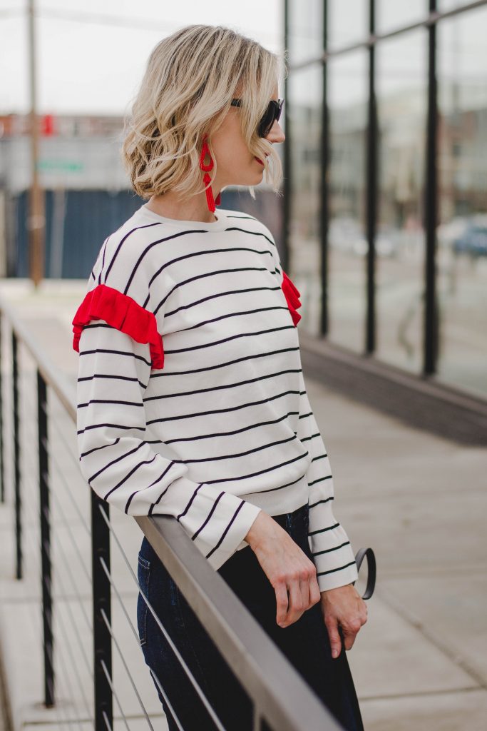 striped top with red ruffle shoulder detail and red statement earrings