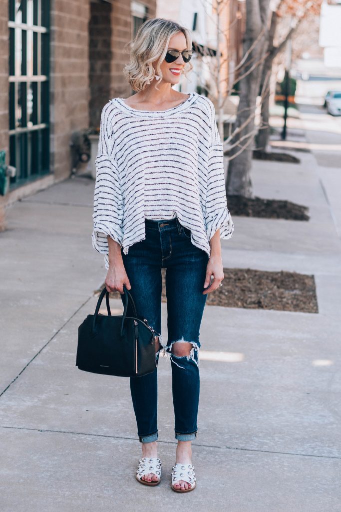 comfy oversized top with jeans and studded white slide sandals