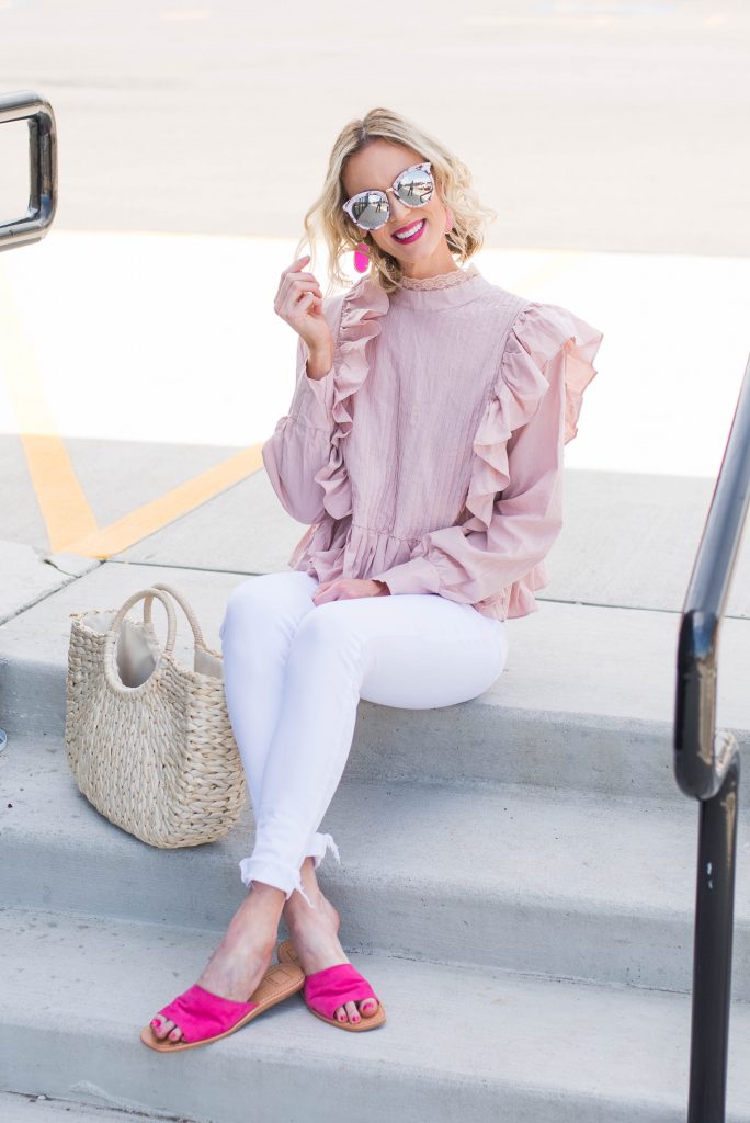 mirrored sunglasses with pink top, white jeans, and bright pink slide shoes