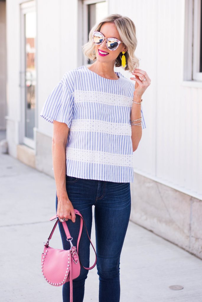 yellow statement earrings with blue and white outfit and pink bag