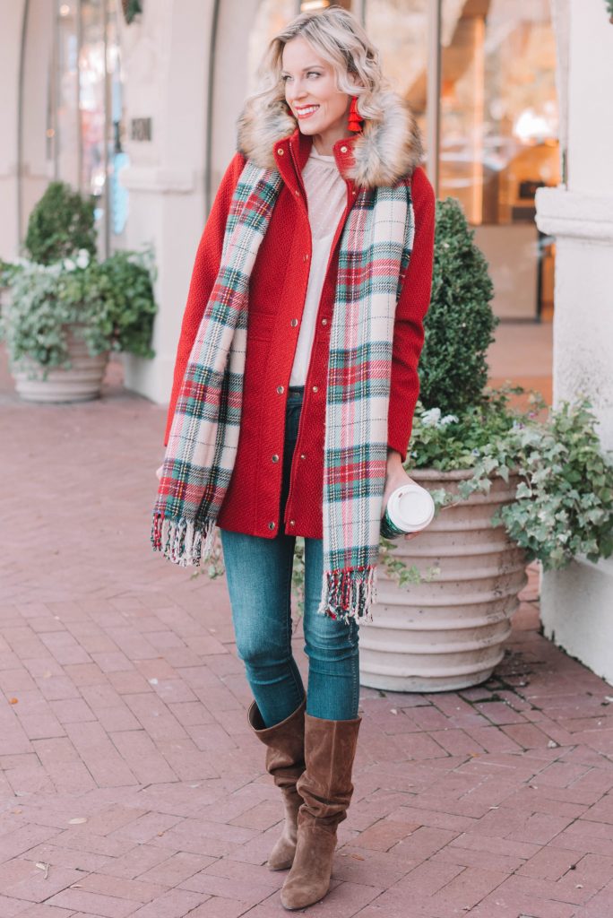 festive Christmas outfit, red coat, plaid scarf, jeans, and boots