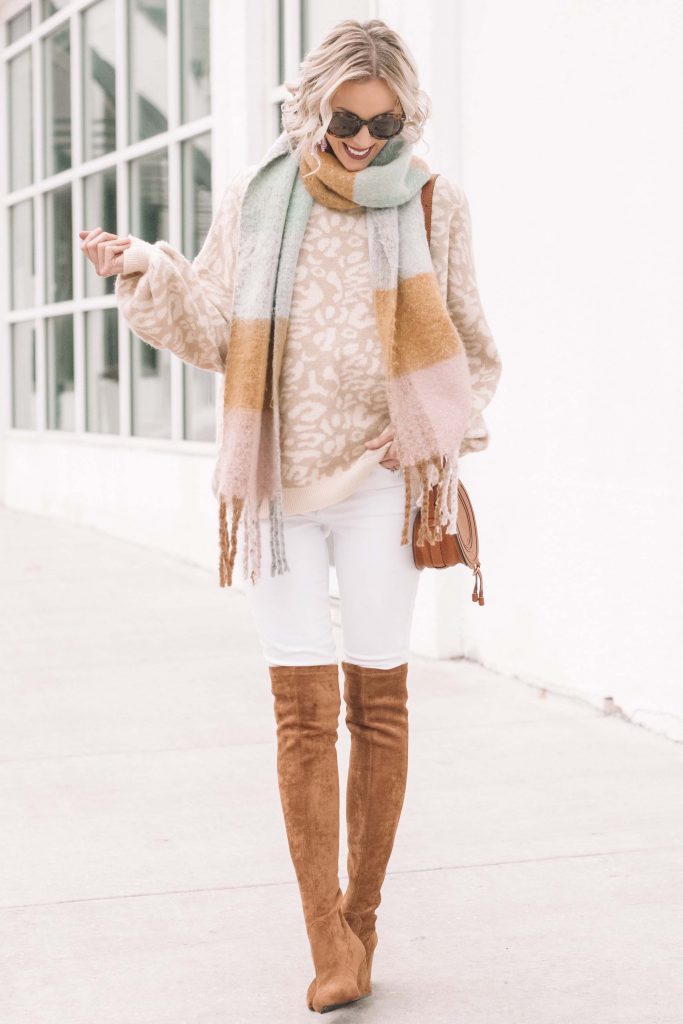 neutral leopard sweater styled with white jeans and camel over the knee boots
