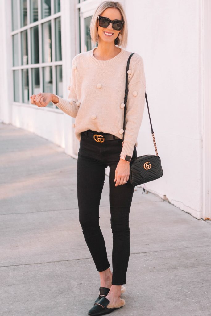 cute and fun cream pom pom sweater with black skinny jeans and gucci dupe slides