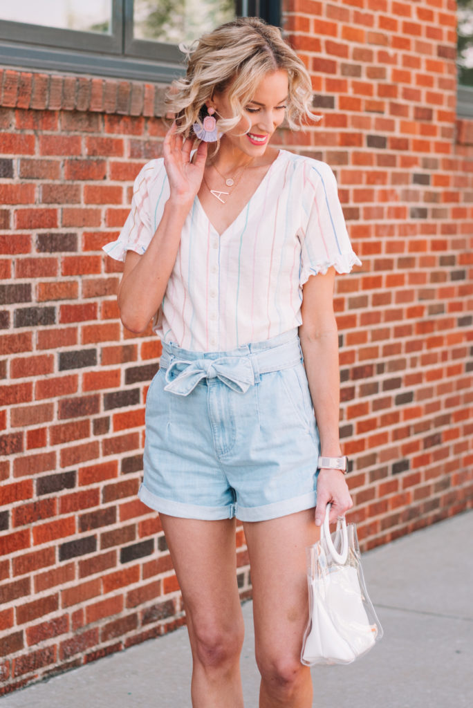 light wash denim paperbag waist shorts with a light colored shirt and fun earrings