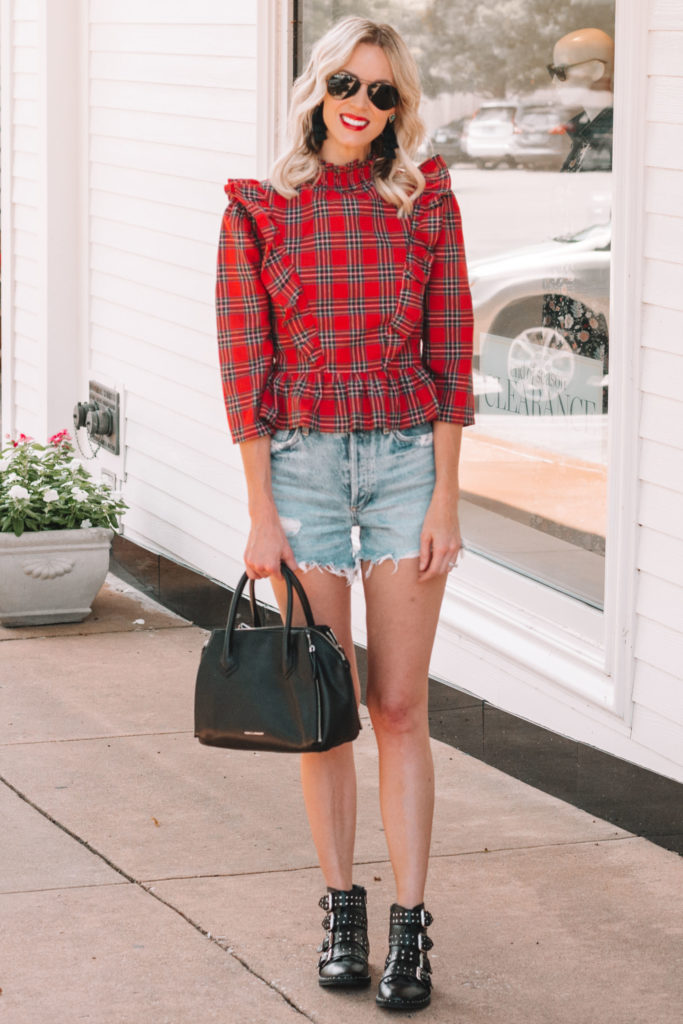 red plaid top with cutoff jean shorts and black buckle boots