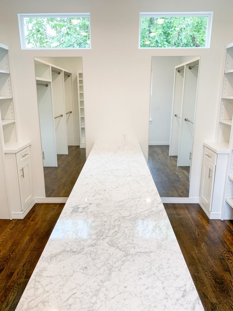 all white master closet dual mirrors and island