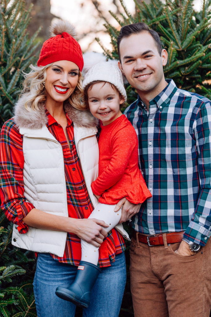 what to wear for family Christmas tree farm photos, Christmas flannel, Christmas plaid, puffer vest, mom and daughter beanies, toddler Hunter boots