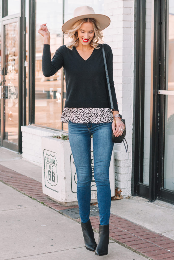 faux layered peplum top, black v-neck sweater, jeans, lack of color hat, cream hat