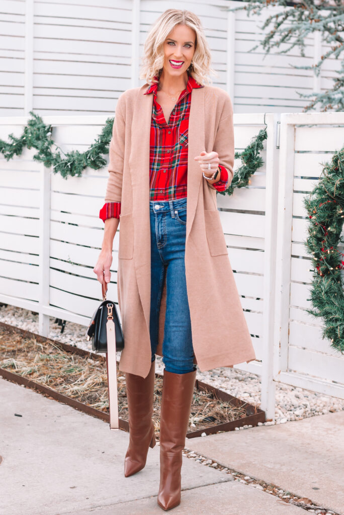Red plaid shirt with camel duster, jeans, and knee high brown boots. 